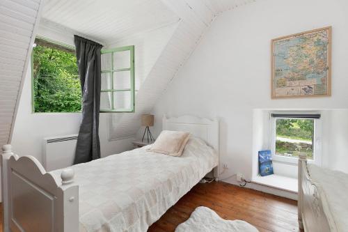 a white bedroom with a bed and two windows at Gîte La P'tite Longère in Saint-Jacut-les-Pins