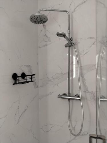 a shower in a bathroom with white marble at Une pause au pied des Pyrénées in Asson