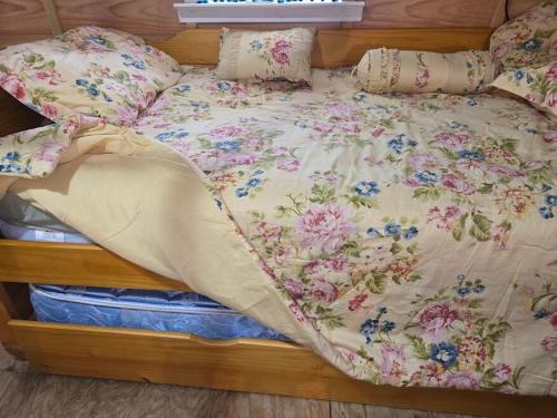 a bed with a floral comforter and pillows on it at The Whip-o-Will in Moss Point
