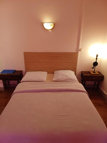 a bedroom with a large bed with a wooden headboard at La Flûte 2 in Thiers