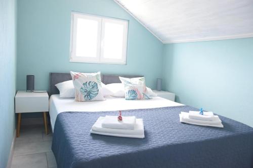 a blue room with a bed with two towels on it at Villa Luger 2 Dachgeschoss in Rogoznica
