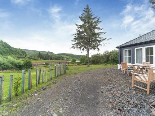 a house with a picnic table and a tree at Tigh Na Clachan in Clachan