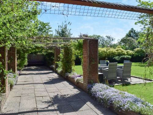 a garden with an arbor and flowers at Swallow Cottage - Uk49756 in Little Singleton