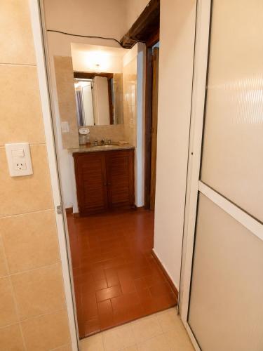 a hallway with a bathroom with a sink and a mirror at Tala in Villa Cura Brochero