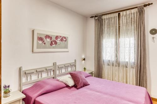a bedroom with a pink bed and a window at Bahia Studio in Empuriabrava