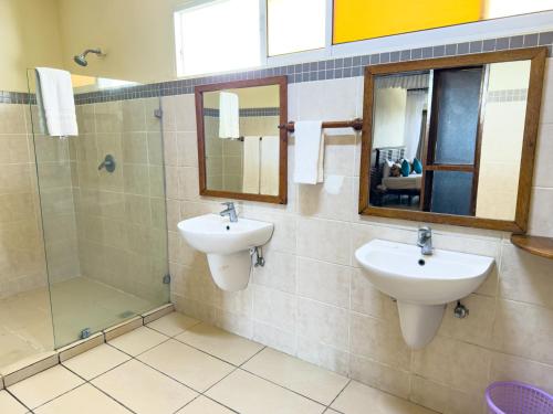 a bathroom with two sinks and a shower at CityBlue Creekside Hotel & Suites in Mombasa