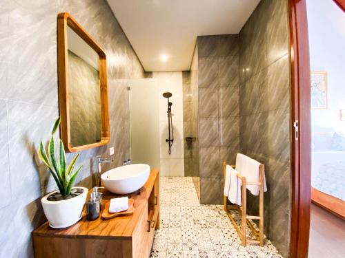 a bathroom with a sink and a mirror at Ardinia Villa Ubud Private Pool in Ubud