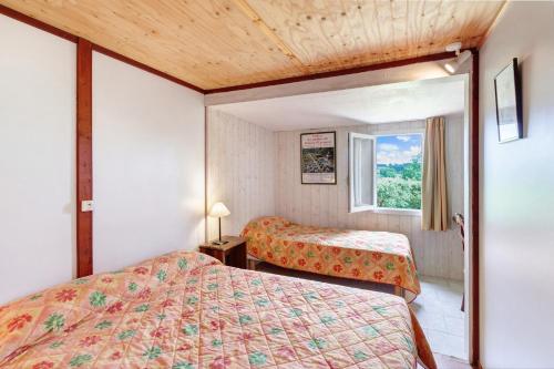 a hotel room with two beds and a window at Chalet Le Chene Vert in Salignac Eyvigues
