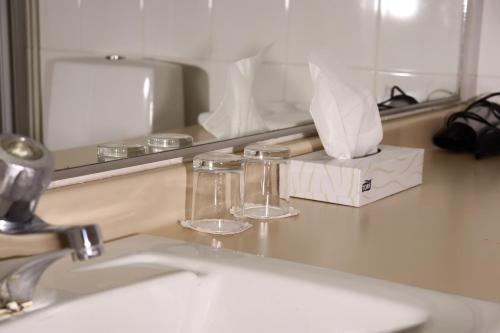 eine Badezimmerablage mit Waschbecken und Spiegel in der Unterkunft Hotel Sommelo in Kouvola