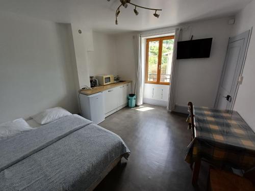 a bedroom with a bed and a table and a window at La Gabare 1 in Thiers