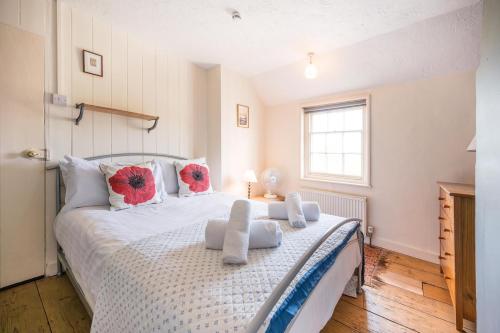 a bedroom with a large bed with red flowers on it at Stuckie Ben, Southwold in Southwold