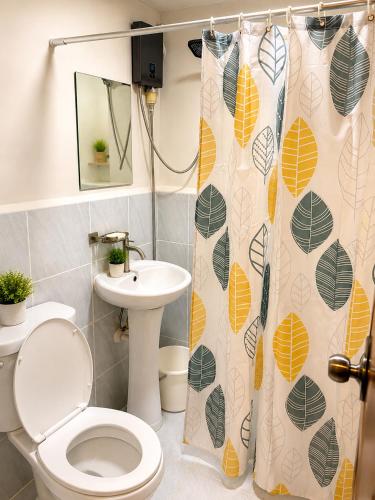 a bathroom with a toilet and a sink and a shower curtain at Arastar Escape - Relax and Unwind- NetFlix - Fast Wifi - Pool Access in Suba