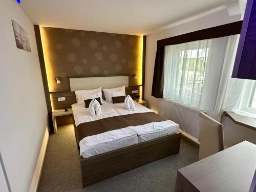 a bedroom with a large bed and a window at Tündérfátyol in Abádszalók