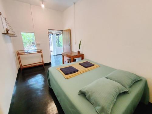 a bedroom with a large green bed in a room at Arugam Bay Beach House in Pottuvil