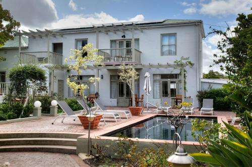a white house with a swimming pool in front of it at Montagu Country Hotel in Montagu