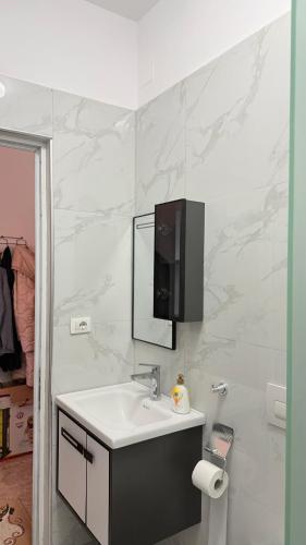 a white bathroom with a sink and a mirror at Fori Vodo in Divjakë