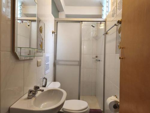 a bathroom with a toilet and a sink and a shower at Killitas home&apart in Cusco