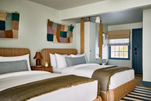 a bedroom with two beds and a window at Hotel Corduroy in Montauk