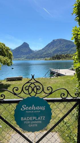 a gate with a sign on it in front of a lake at Seehaus Familie Leifer in St. Wolfgang