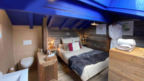 a bedroom with a bed and a blue ceiling at Micro-lodge, Le Petit Nid d'Amour in Montriond