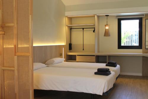 a bedroom with two beds and a window at Makāi Bungalows in Playa del Aguila