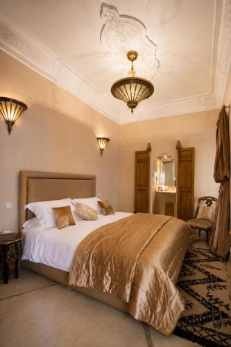 a bedroom with a large bed and a chandelier at Riad Zamzam & Spa in Marrakesh