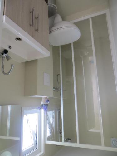 a bathroom with white cabinets and a glass shower at Boerderijcamping Plantlust in Veere