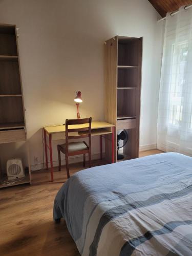 a bedroom with a bed and a desk and a chair at La Petite Pierre d'Octave Nr 1 in Saint Laurent Nouan