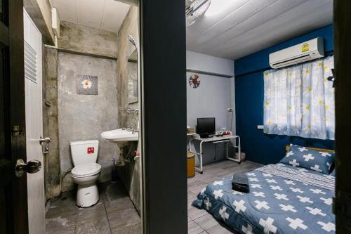 a bathroom with a bed and a sink and a toilet at Malai Place Lampang in Lampang