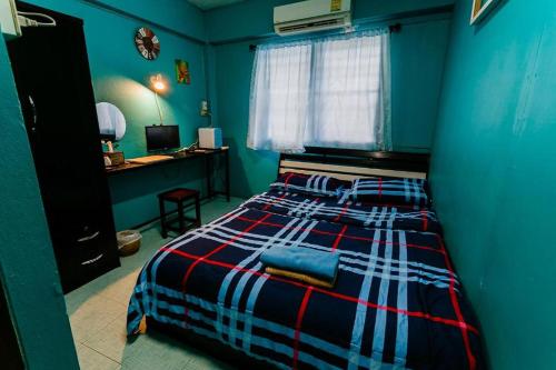 a blue bedroom with a bed and a desk at Malai Place Lampang in Lampang