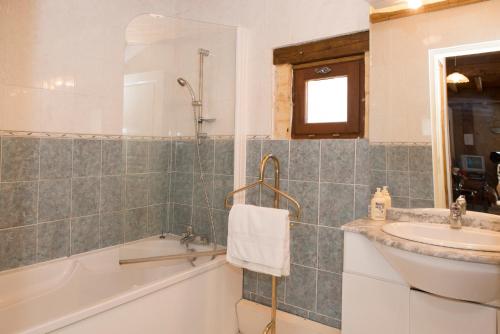 a bathroom with a bath tub and a sink at gites de la Vaysse in Vergt-de-Biron