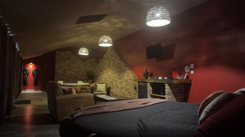 a bedroom with a bed and a couch and a fireplace at chambre INNAMORATO avec jacuzzi lit rond et jardin avec piscine in Saint-Martial-sur-Né