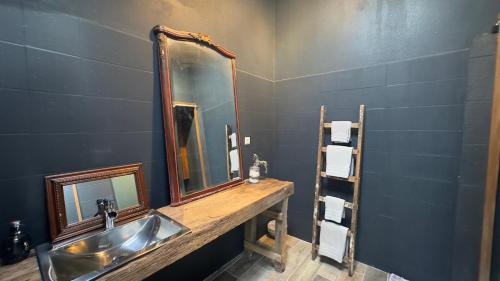 a bathroom with a sink and a mirror at chambre INNAMORATO avec jacuzzi lit rond et jardin avec piscine in Saint-Martial-sur-Né