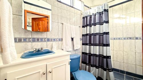 a bathroom with a blue toilet and a sink at Galapagos Family Vacation 3 bedrooms 7 guests Centrally located and ocean view in Puerto Ayora