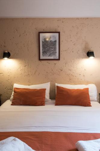 a bedroom with a bed with orange and white pillows at Hotel Samka in Salta