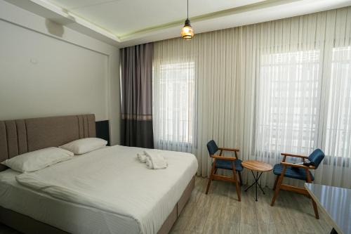 a hotel room with a bed and two chairs at Tk Residence in İzmir