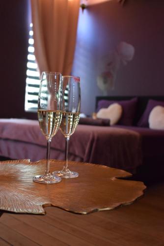 two glasses of champagne sitting on a table at La Muse Ment - Suite La Valtesse de la Bigne in Liège