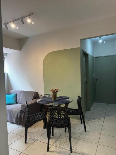 a living room with a table and chairs and a couch at Aconchegante Apartamento in Lavras