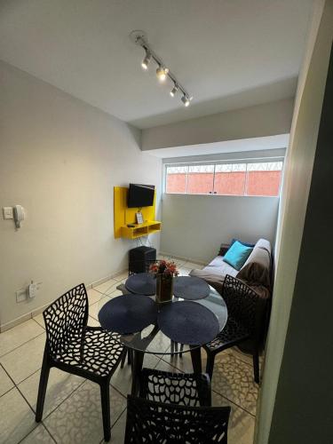 a living room with a table and chairs and a couch at Aconchegante Apartamento in Lavras