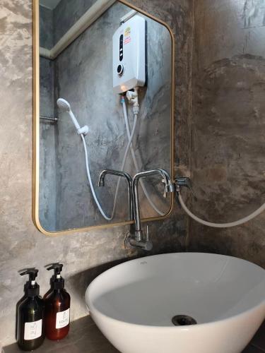 a bathroom with a sink and a soap dispenser at Dungkaew lakeview resort in Amphoe Ban Dung