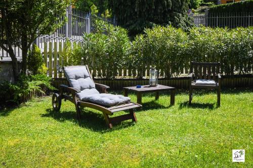 a yard with a chair and a table in the grass at Appartamenti La Menaresta quiet & relax near Bellagio in Magreglio