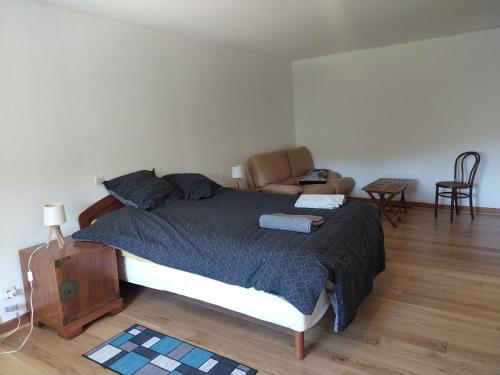 a bedroom with a bed and a living room at Grès Vaillant in Saint-Polycarpe
