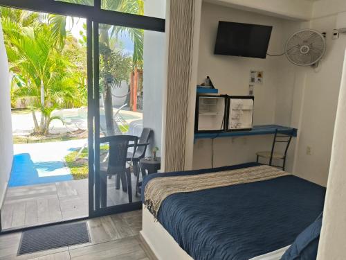 a bedroom with a bed and a view of a pool at teki-sha home&suites in Bacalar