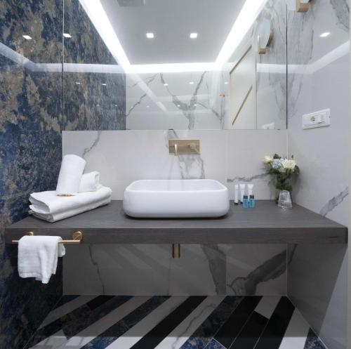 ein Badezimmer mit Waschbecken und Spiegel in der Unterkunft Hotel Cala Moresca in Bacoli