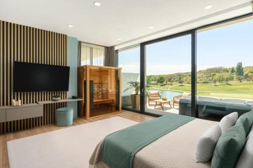 a bedroom with a flat screen tv and a bed at Evergreen Health Longevity Residence in Kehidakustány