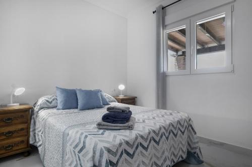 a bedroom with a bed with blue pillows and a window at Casa de Piedra in El Cañal
