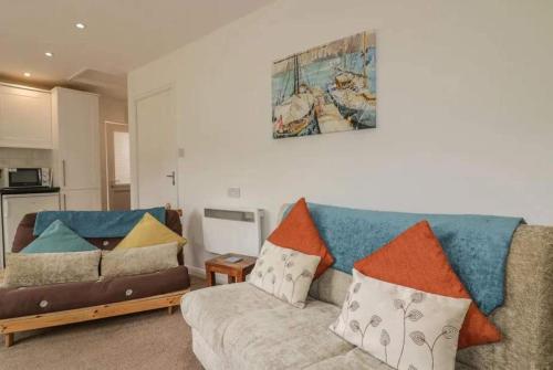 a living room with a couch with pillows on it at Bungalow - Sleeps 2 - Parking in Newquay