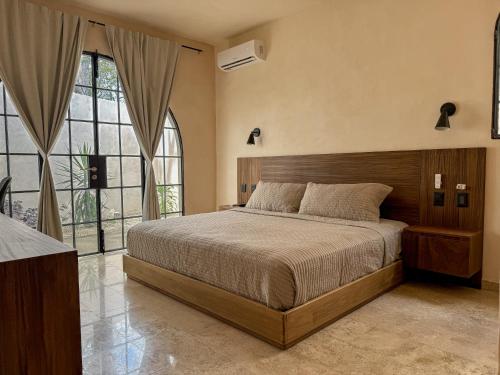 ein Schlafzimmer mit einem Bett und einem großen Fenster in der Unterkunft Casa Bacah in Bacalar