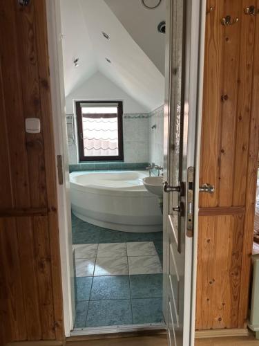 a bathroom with a large tub and a sink at Zacisze Zbiczno in Zbiczno