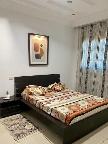 a bedroom with a large bed with a comforter at Le palmier in Mezraya